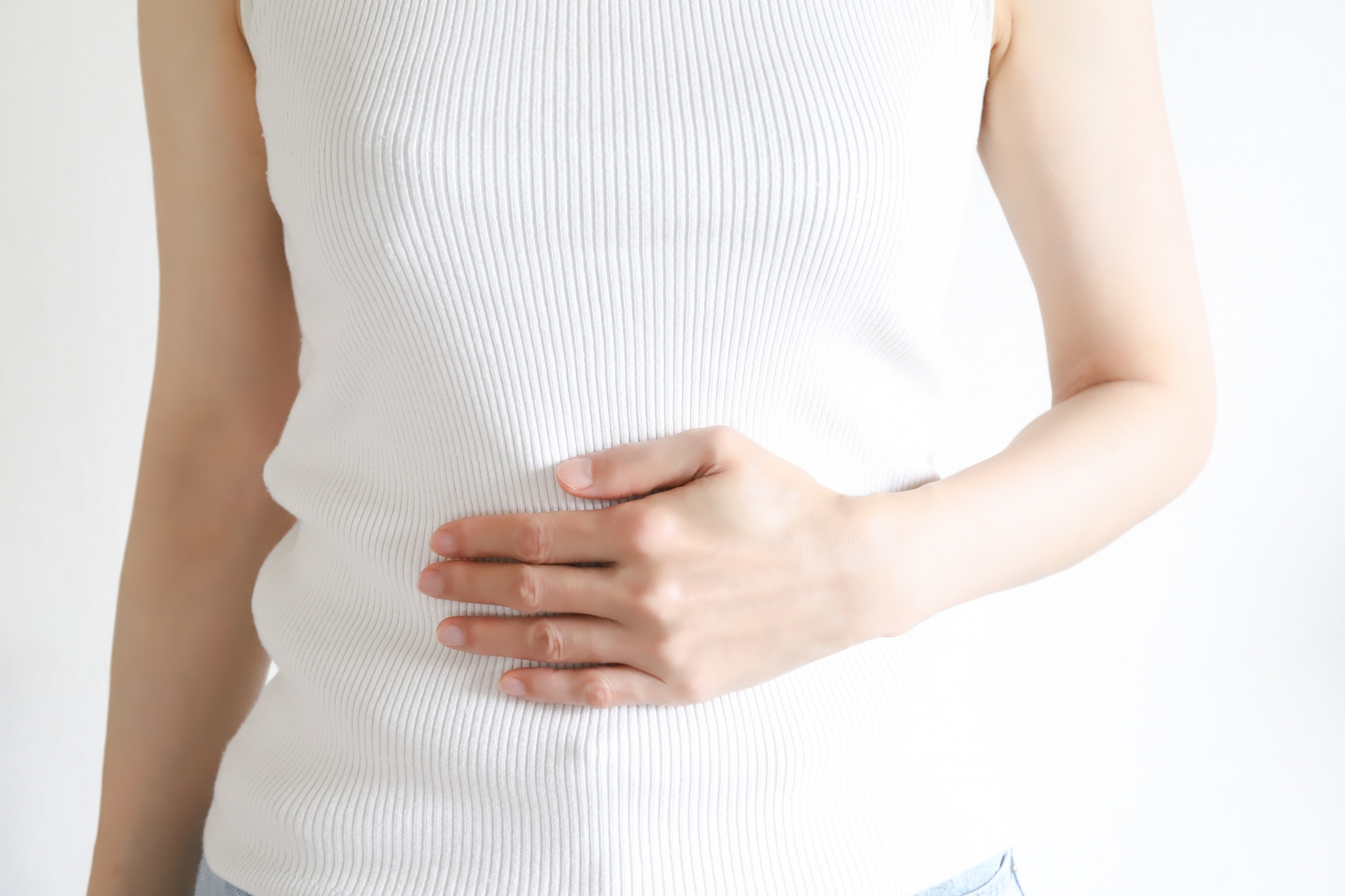お腹の張りを気にしてそっと手を当てる女性