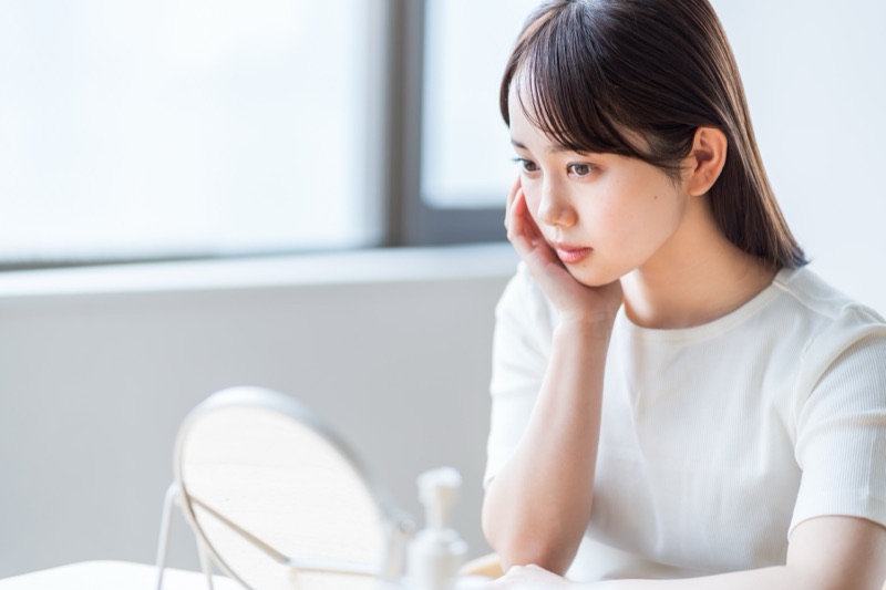 口臭の原因を考える女性