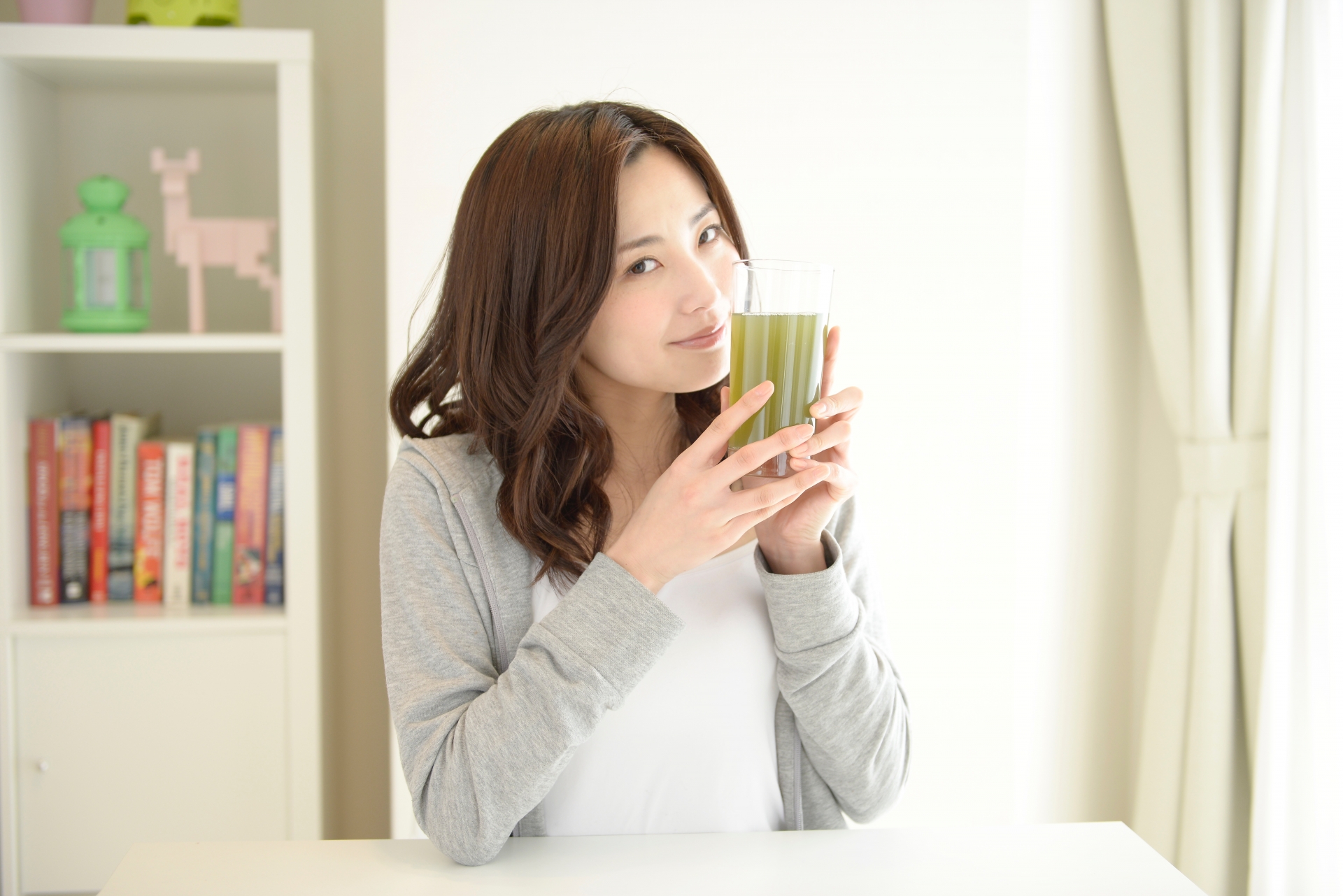 グリーンスムージーと新鮮な緑の野菜が並ぶ明るいキッチンカウンター