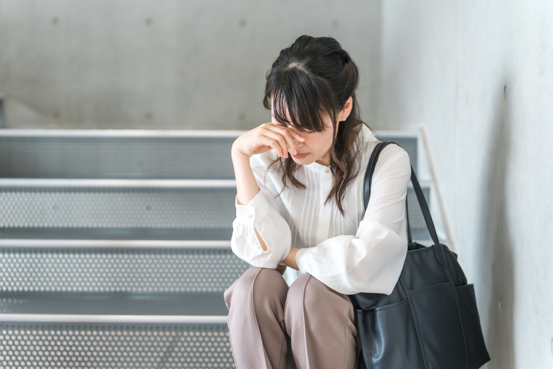 疲れた表情でデスクに肘をついて休む人