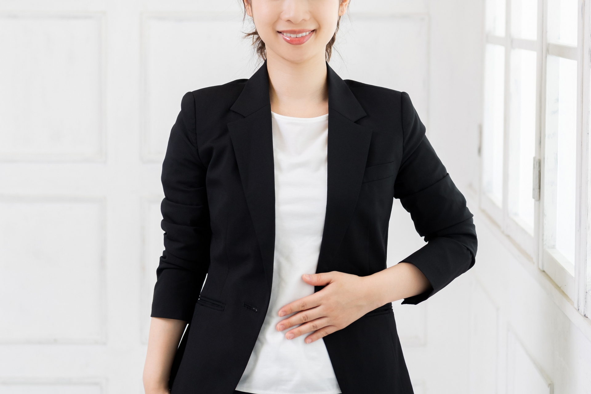 お腹に手を当てて腸の調子を気にかける女性