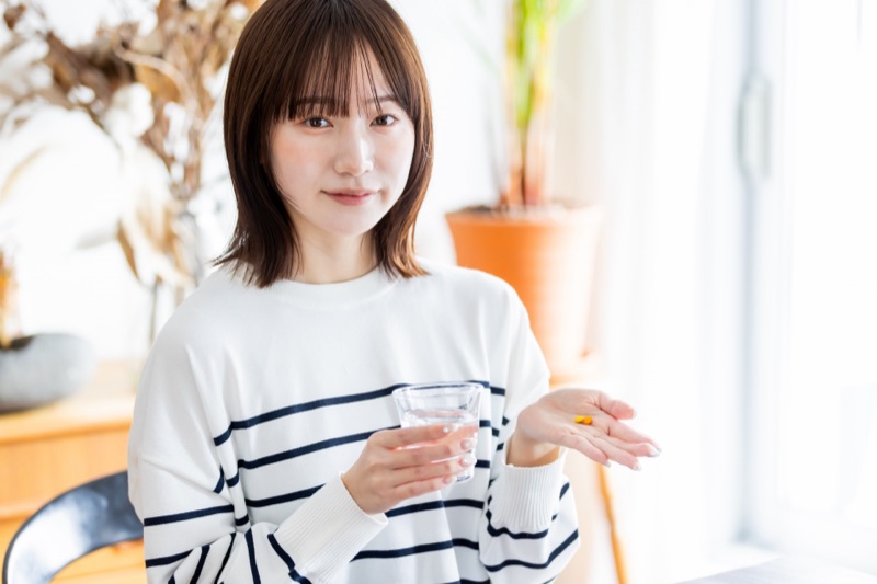 タブレットを口に運ぶナチュラルな女性