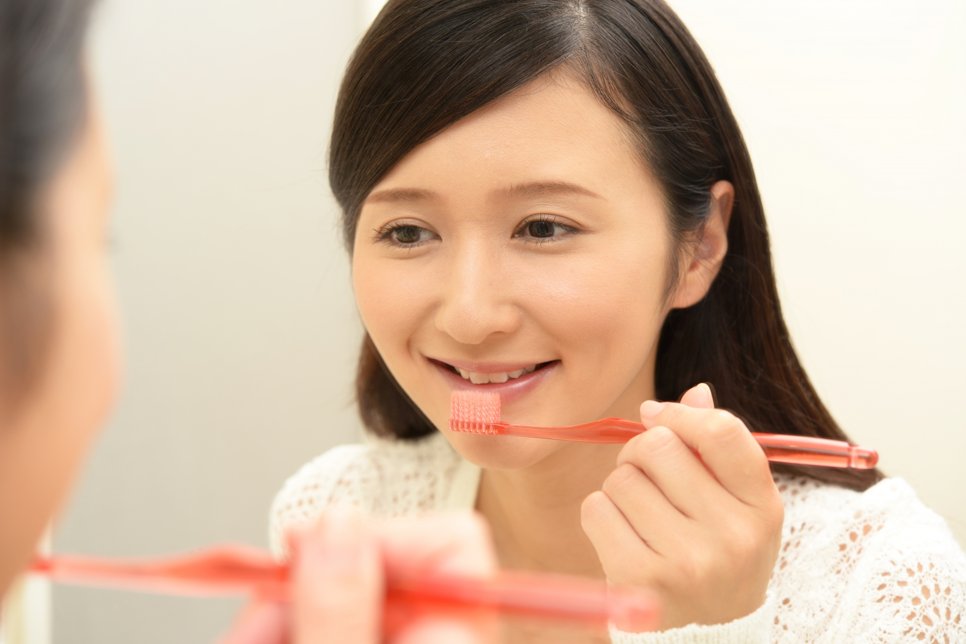洗面台で歯磨きをする20〜30代の女性