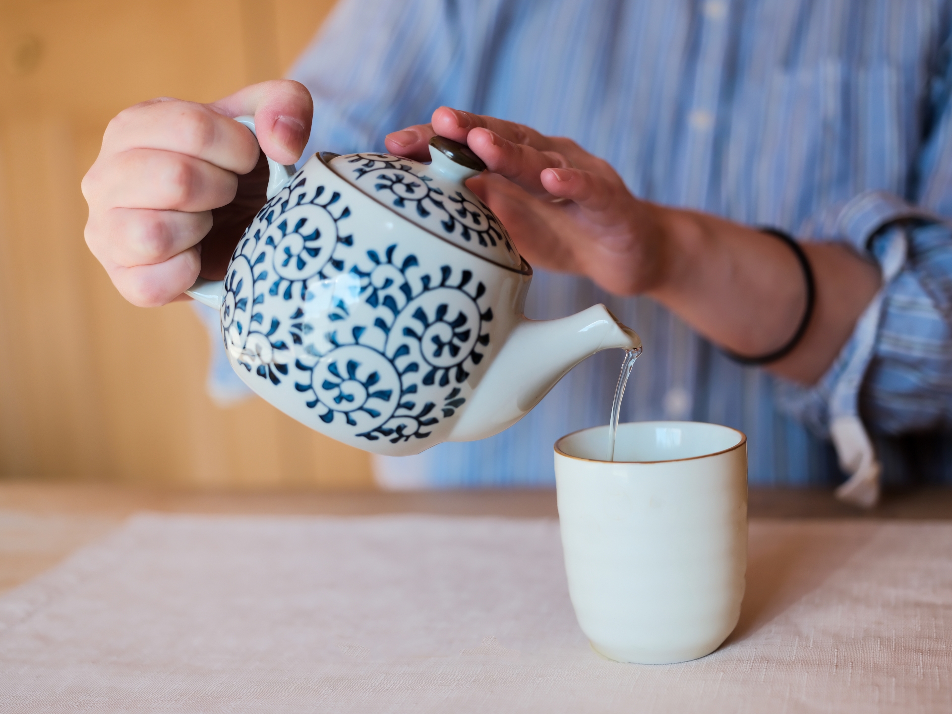急須から湯呑みに緑茶を注ぐ和の食卓風景