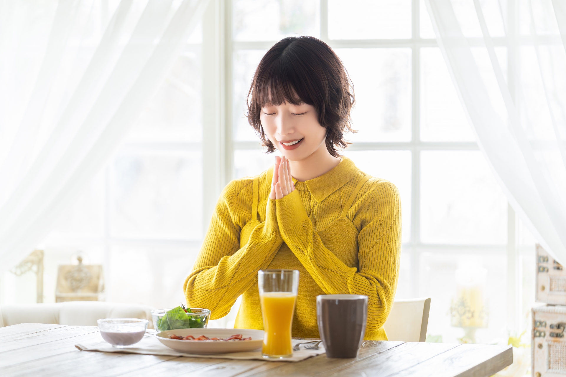 朝の自然光のなかで健やかに過ごす女性