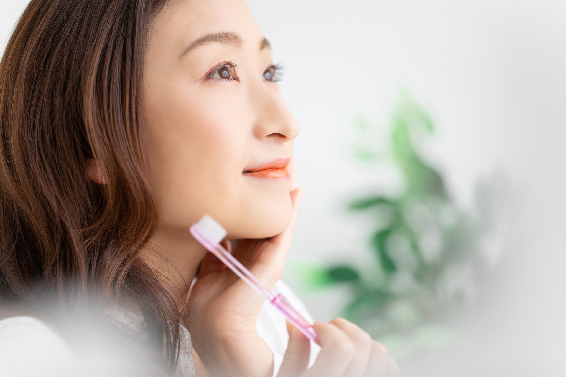 口元に手を添えて爽やかな表情の女性