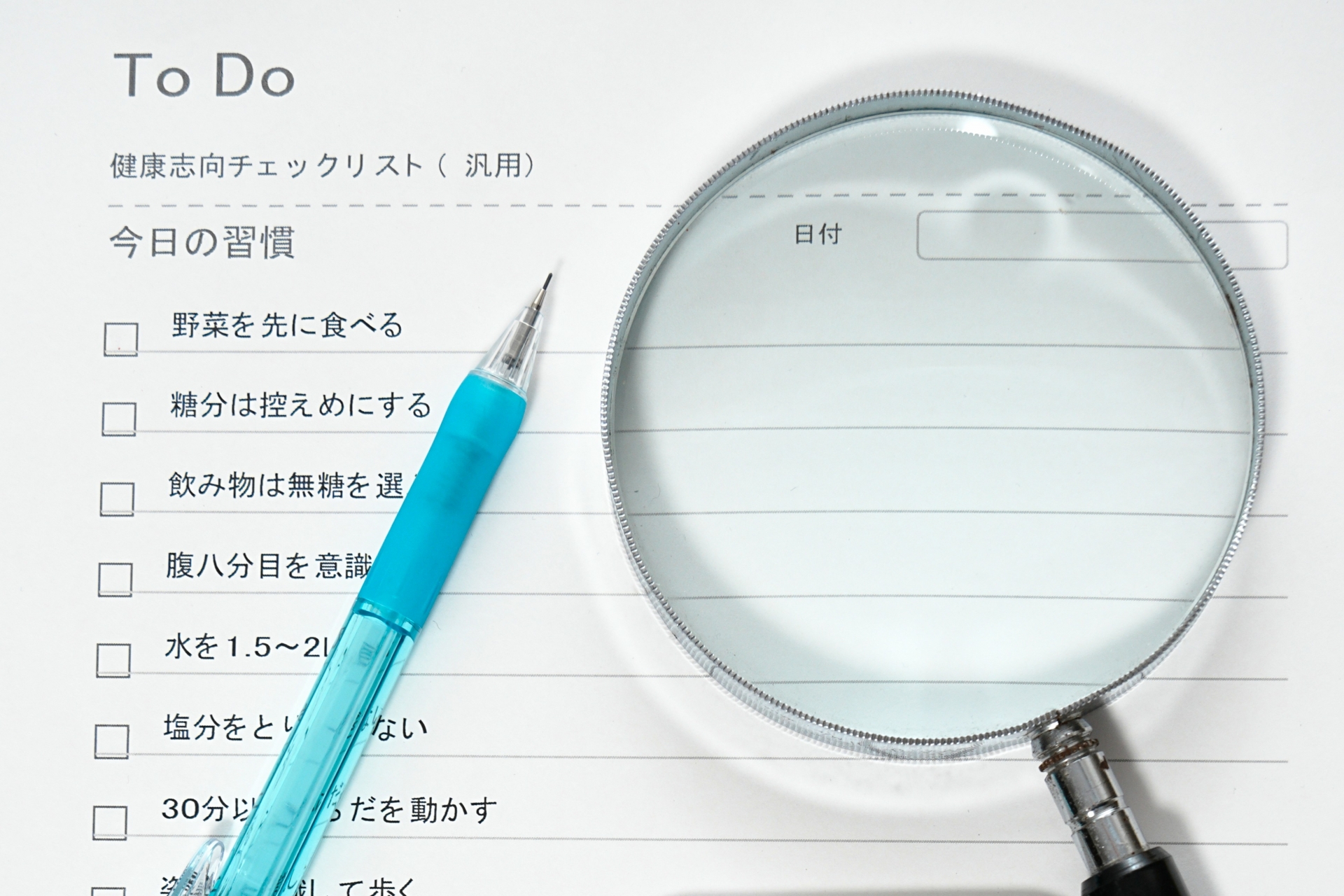 チェックリストにペンで記入する手元