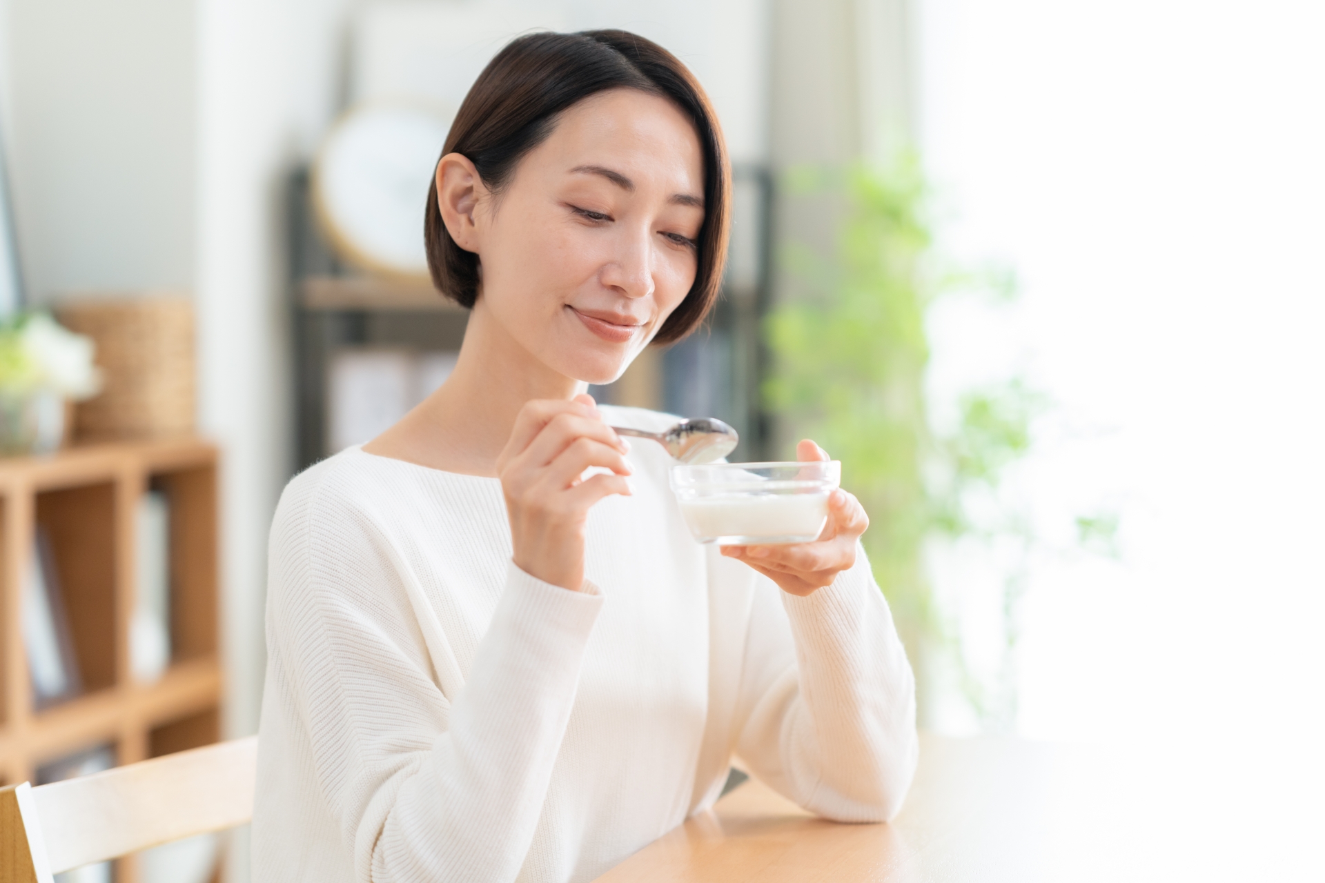 テーブルに並ぶ複数のサプリメントを選ぶ女性の手元