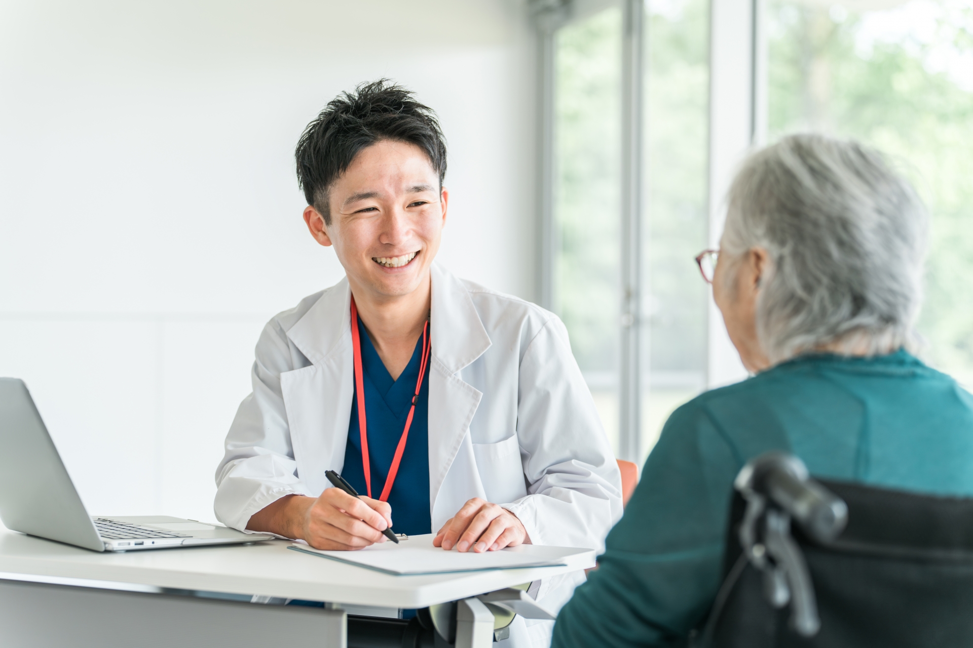 医師に相談している患者の横顔と穏やかな診察室の様子