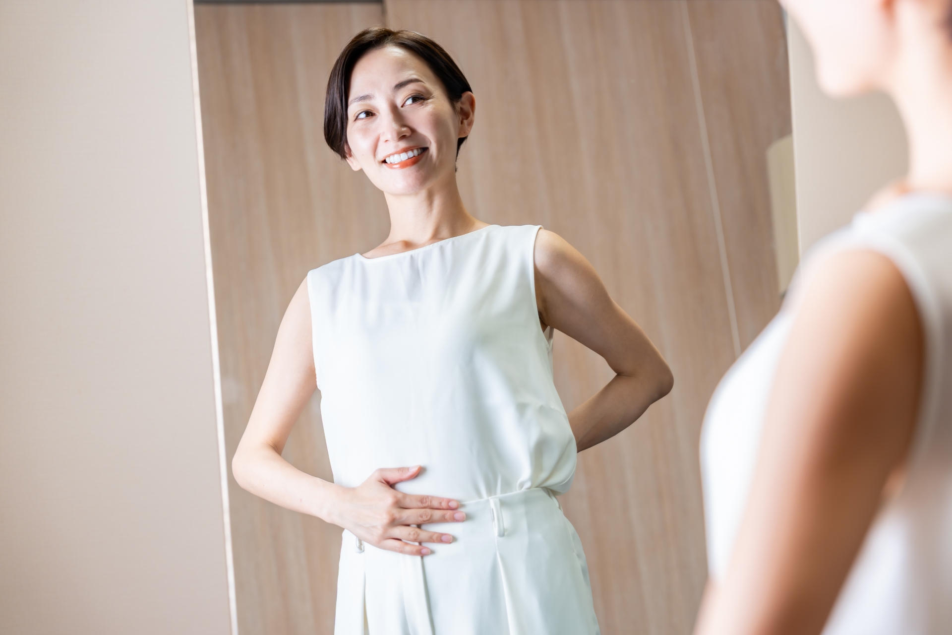 お腹に手を添えて腸の調子を意識する女性
