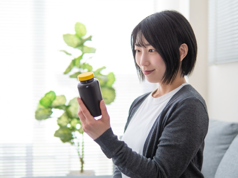 朝の食卓にサプリメントとヨーグルトが一緒に置かれた手元