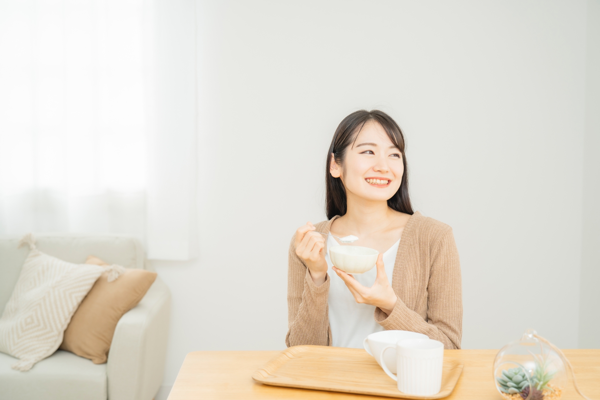ヨーグルトや納豆などの発酵食品とサプリメントが並ぶ食卓の俯瞰写真