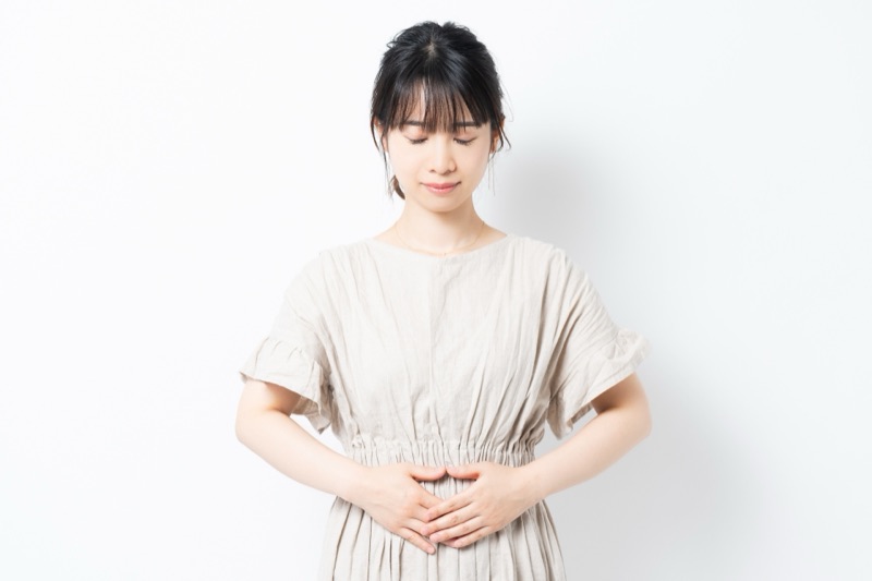 お腹の不調を気にする女性