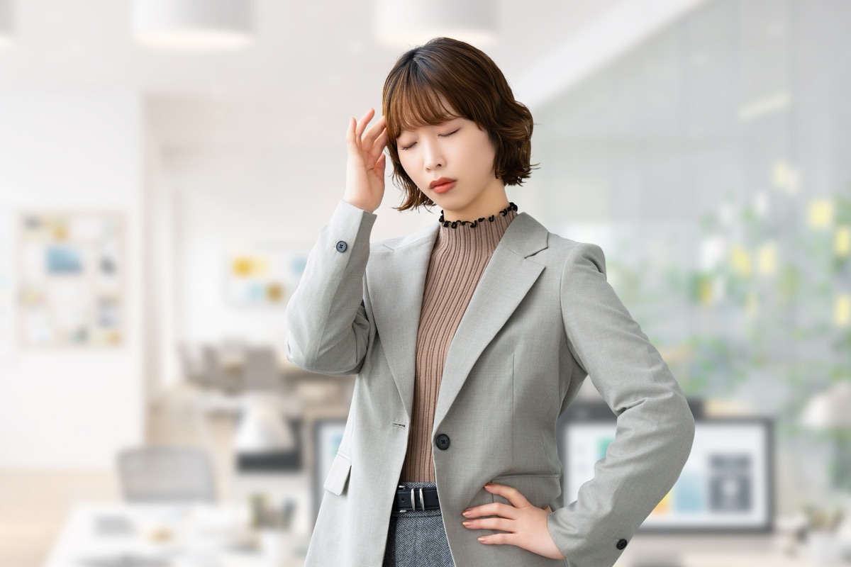 トイレで便の色が気になり不安な表情を浮かべる女性のイメージ