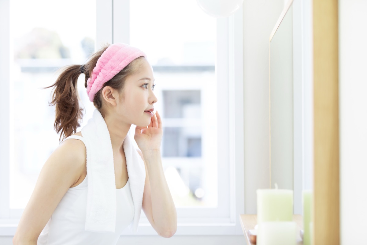 鏡で口元・舌の状態をチェックする女性のイメージ