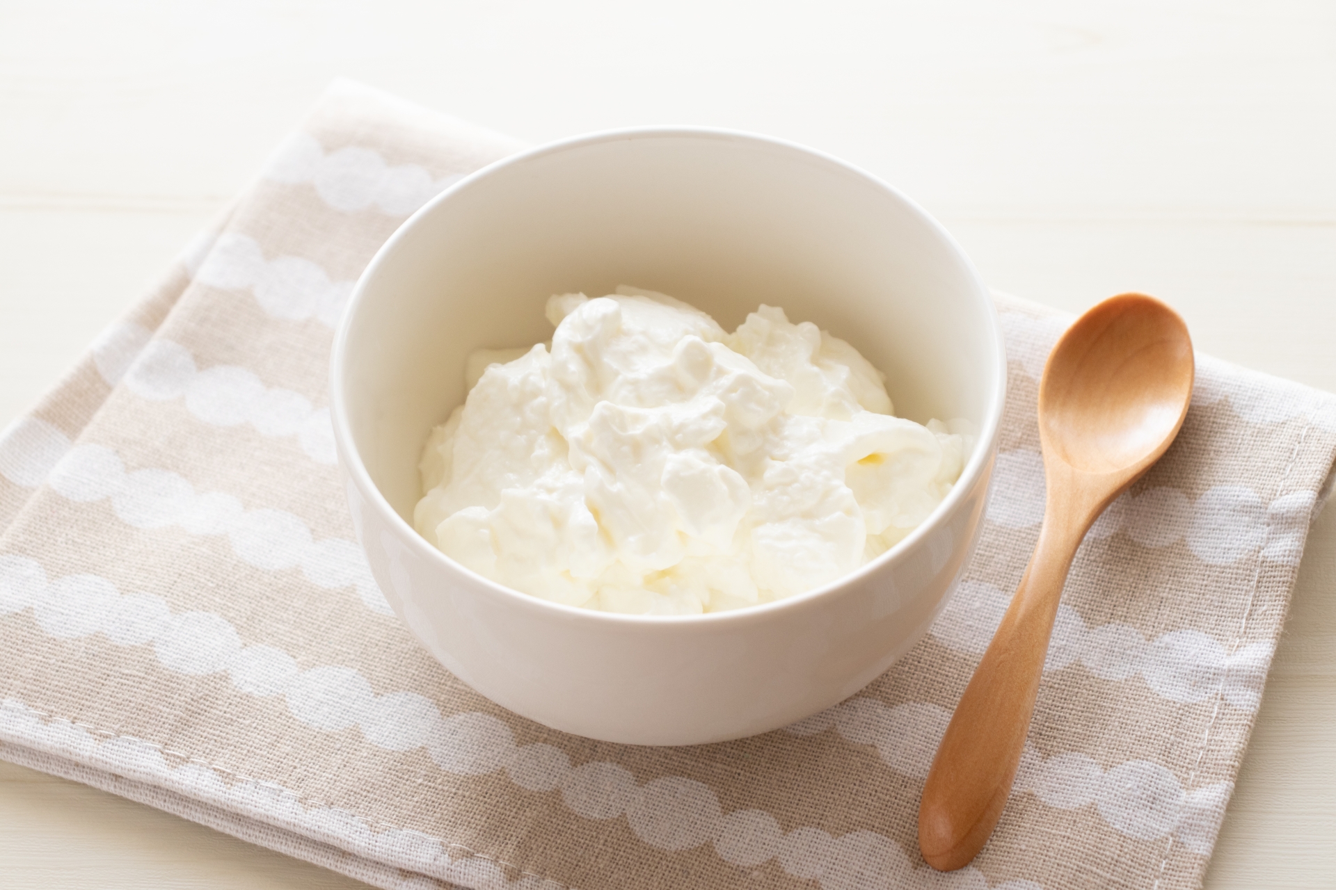 白い器に盛られたなめらかなプレーンヨーグルト｜牛乳を発酵させた身近な発酵食品のイメージ