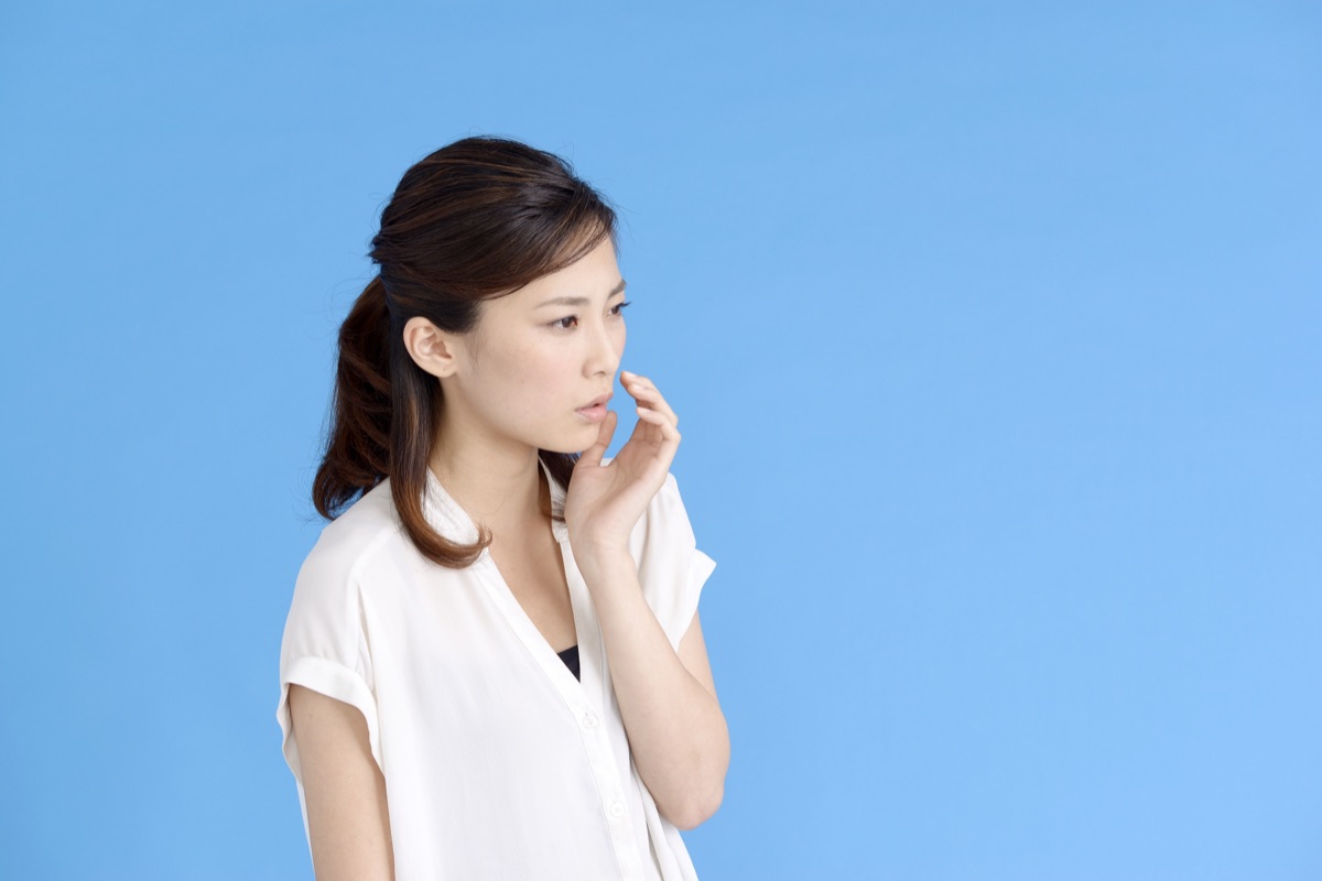 口臭が気になり口元を気にする女性のイメージ