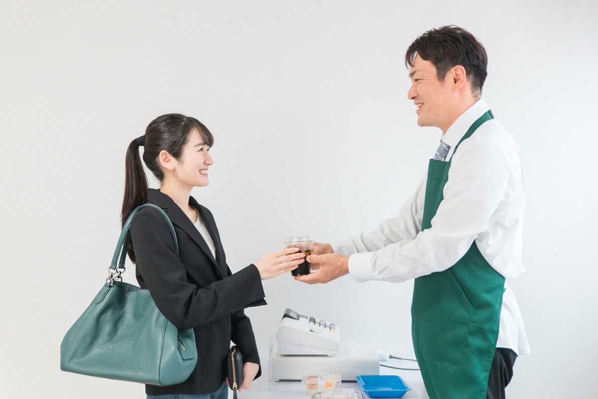 コンビニで乳酸菌飲料を選ぶ女性のイメージ