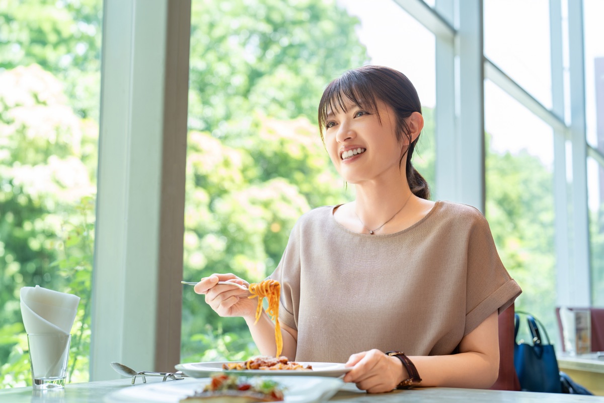 食事を楽しみながら満足そうにしている女性のイメージ