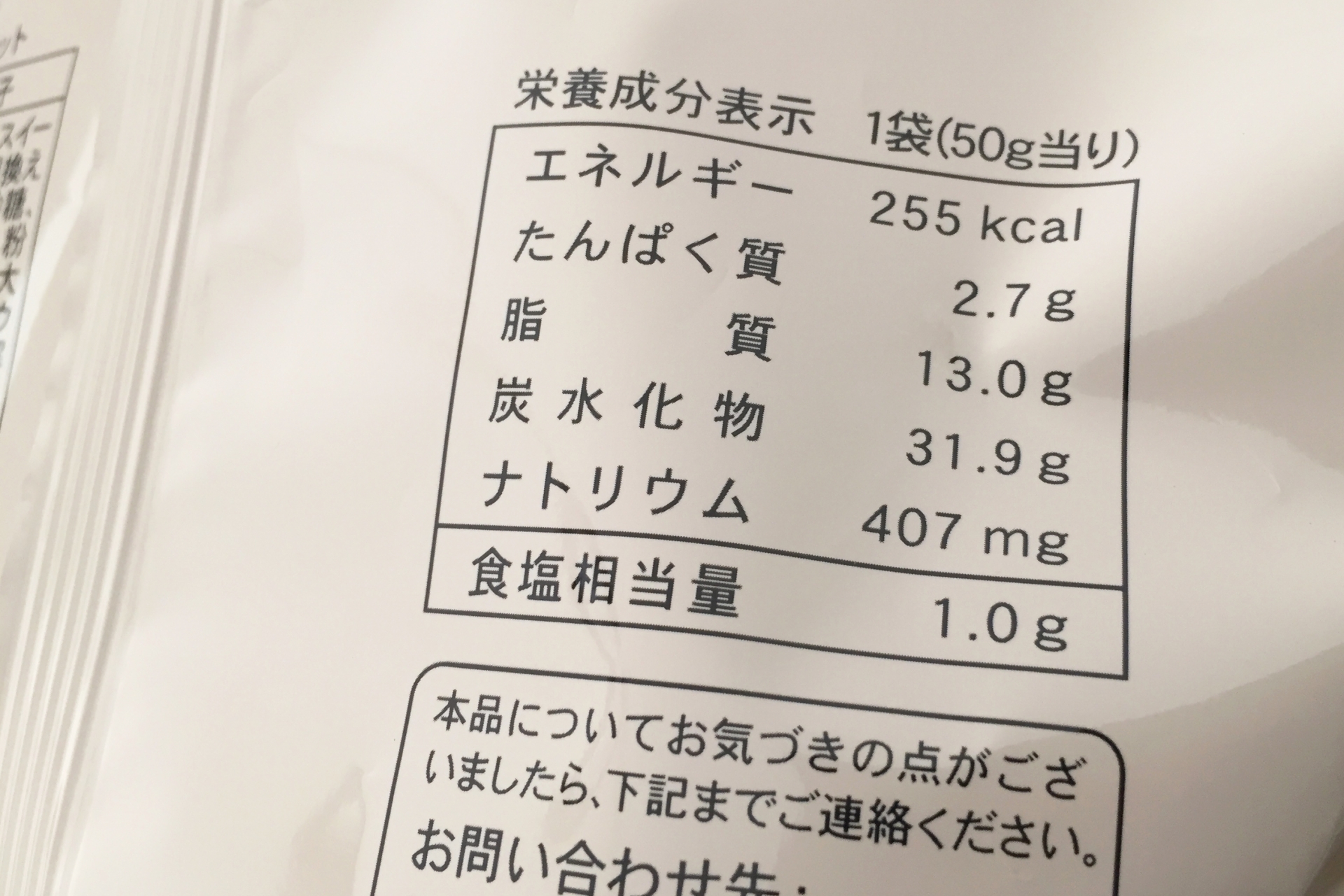 プロテインのパッケージ裏面の成分表示を確認している手元