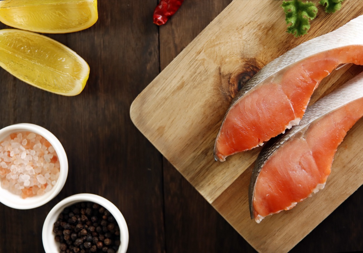 まな板の上で切り身魚に調味料をまぶす手元のイメージ