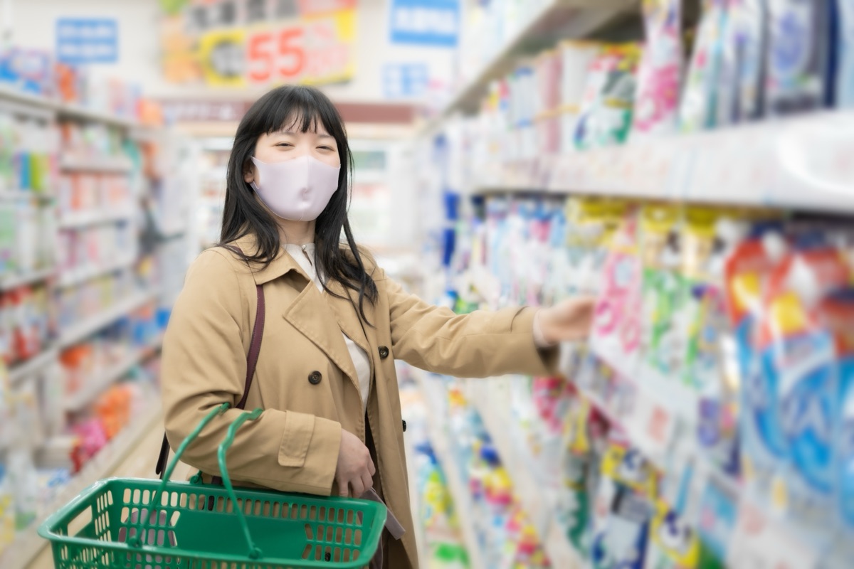 ドラッグストアの棚で市販品を選ぶ女性のイメージ