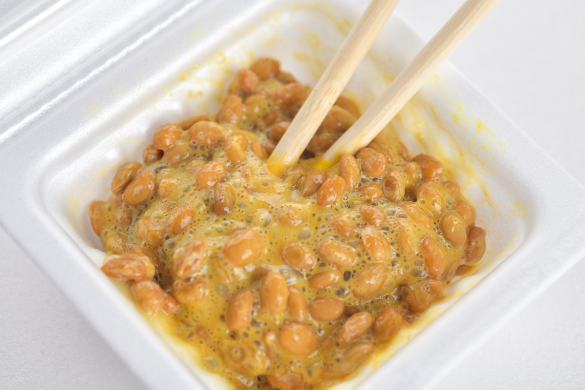 箸で納豆をよく混ぜる手元｜栄養を逃さない食べ方のイメージ