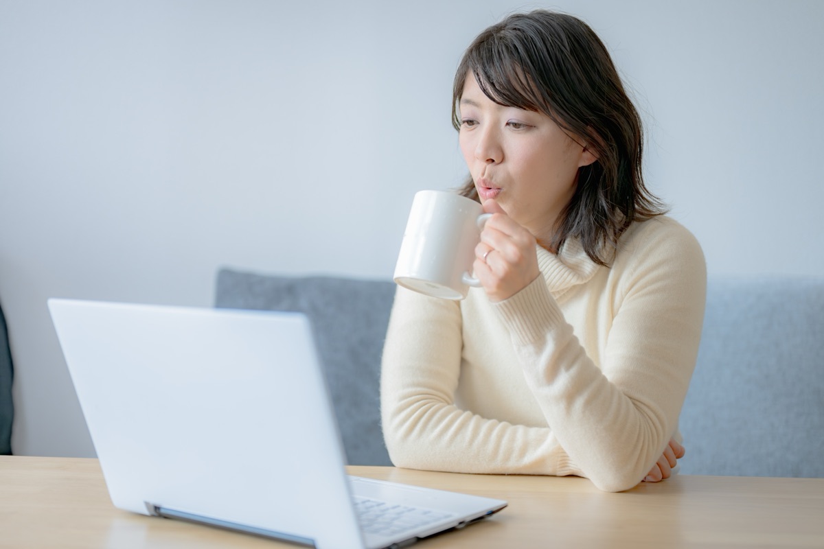 熱い飲み物を少しずつゆっくり口に運ぶ女性のイメージ
