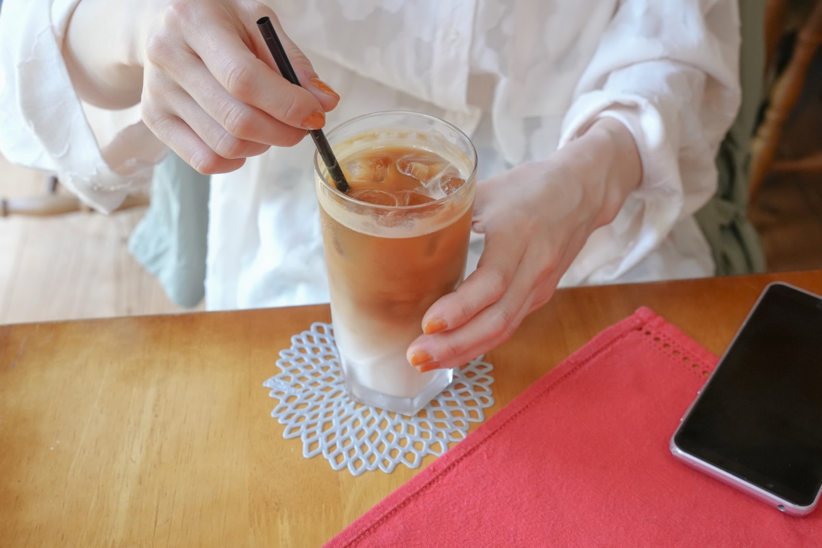 冷たい飲み物を一気に飲もうとする女性のイメージ