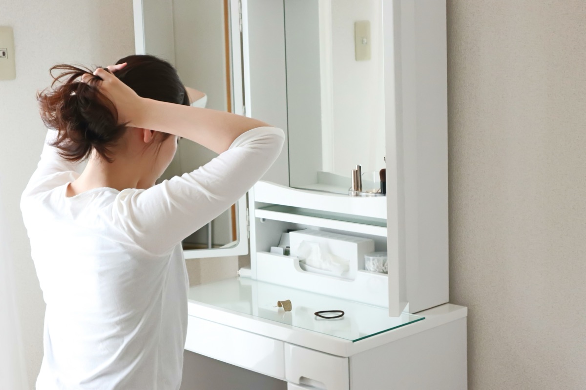 髪をまとめて身支度をする女性のイメージ