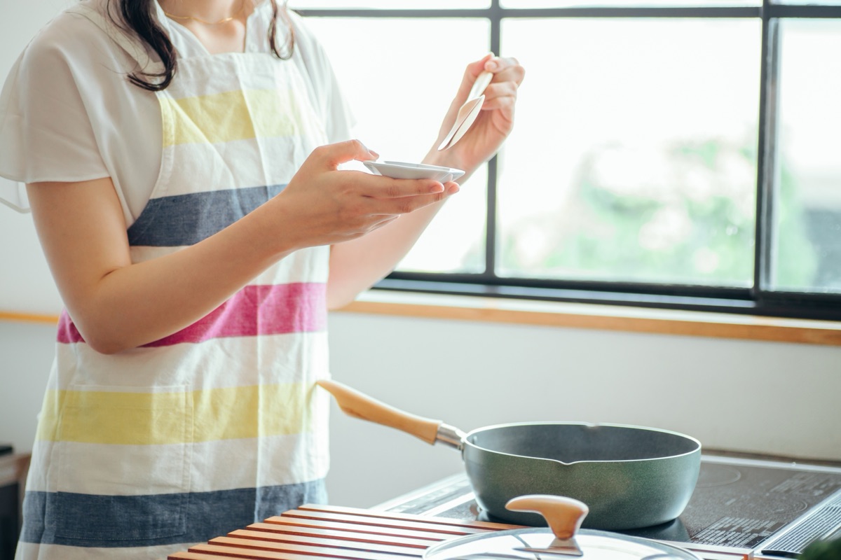 キッチンで漬物を味見して味の加減を確かめる様子のイメージ