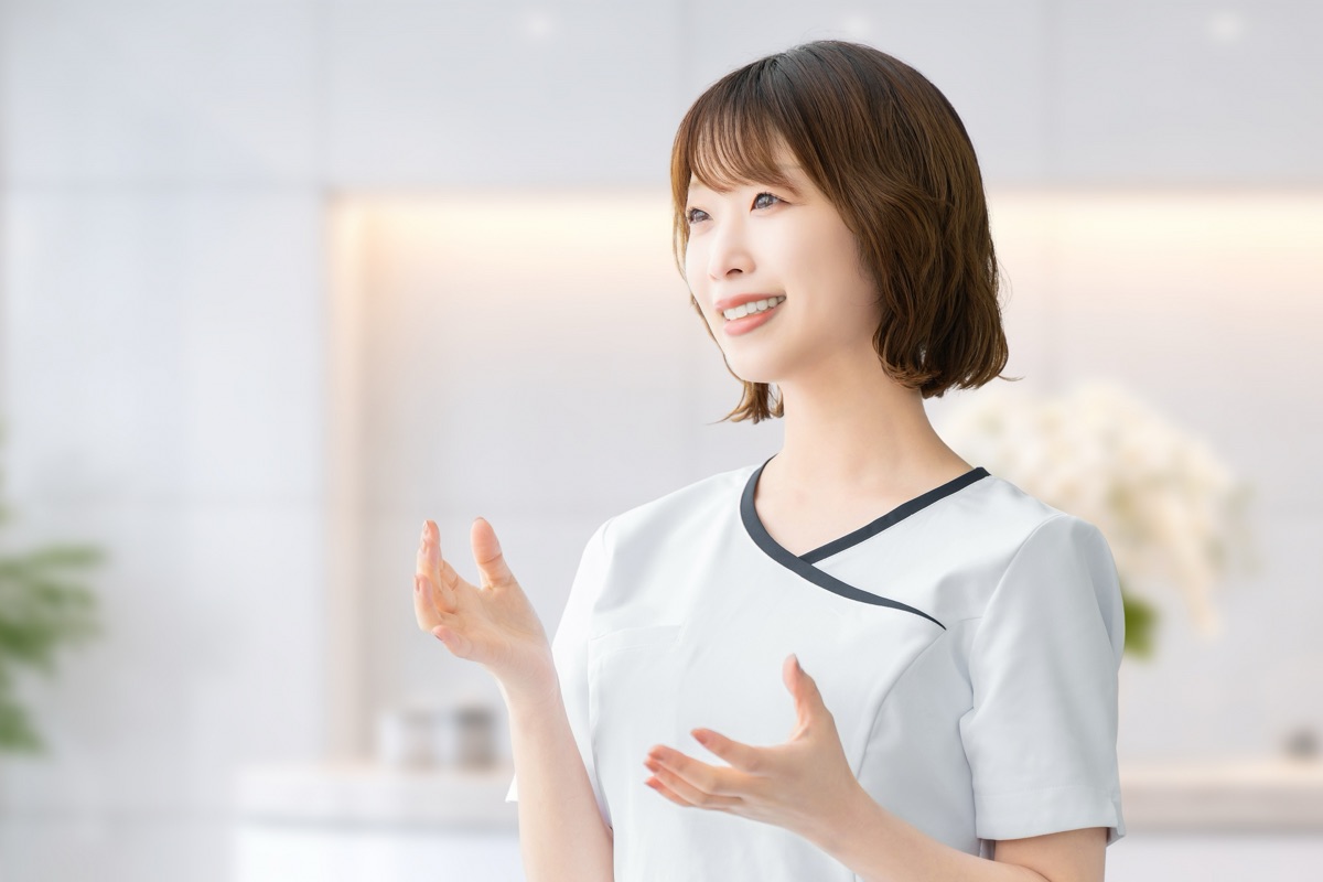 サロンの受付でスタッフに体調を伝える女性のイメージ