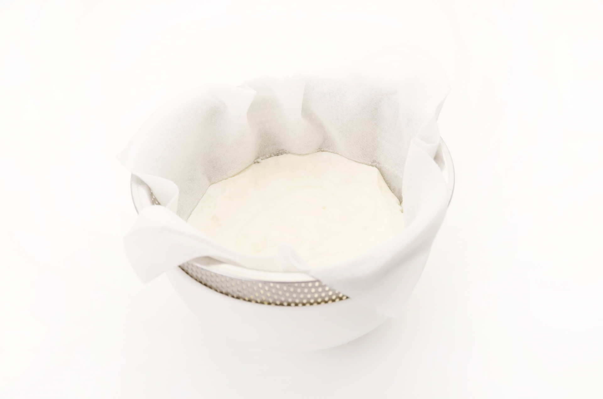 ざるで水切りした濃厚なヨーグルトと下にたまったホエー(乳清)|水切りヨーグルトとホエー活用のイメージ