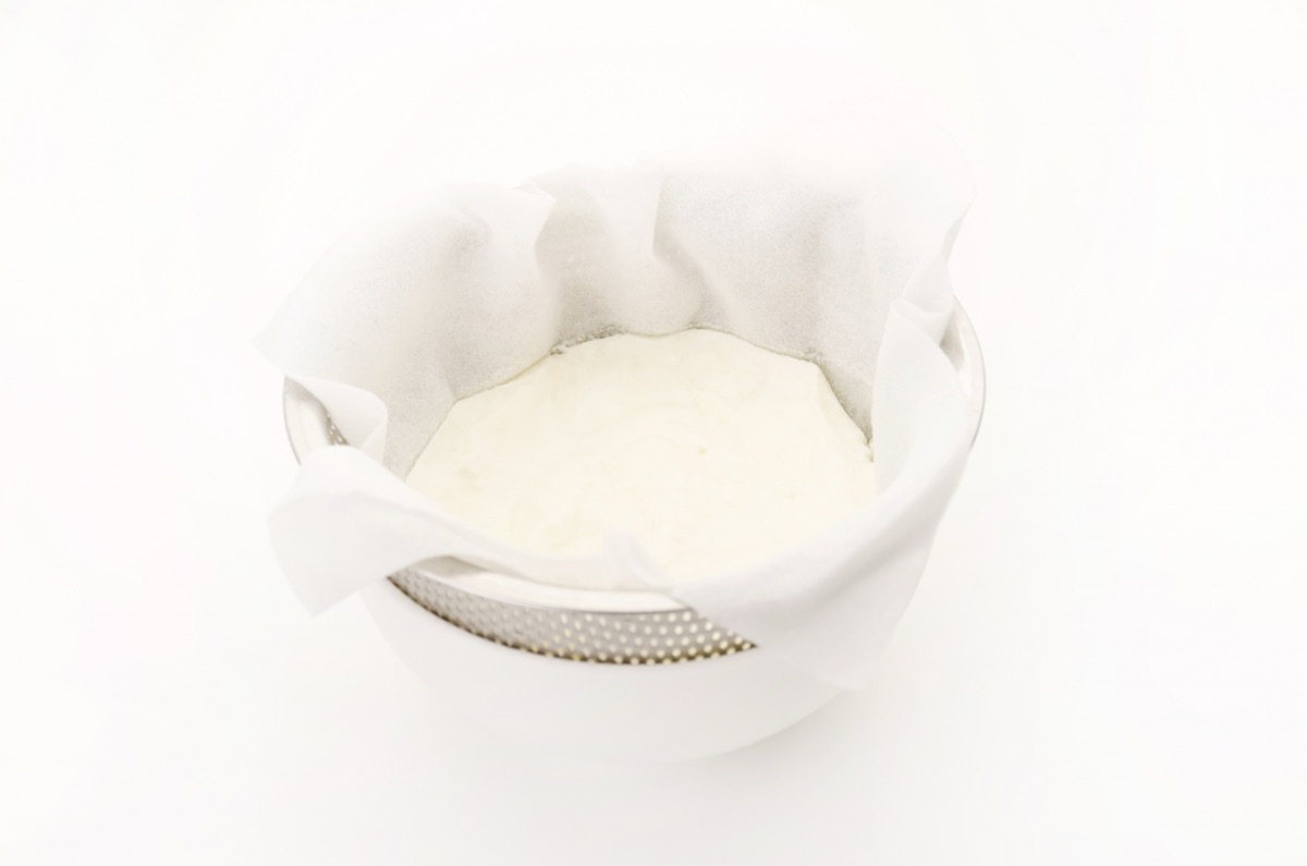 ざるで水切りした濃厚なヨーグルトと下にたまったホエー（乳清）｜水切りヨーグルトとホエー活用のイメージ