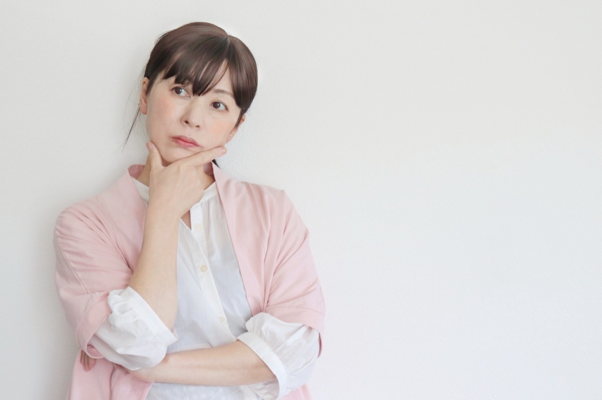 疑問を思い浮かべる女性のイメージ