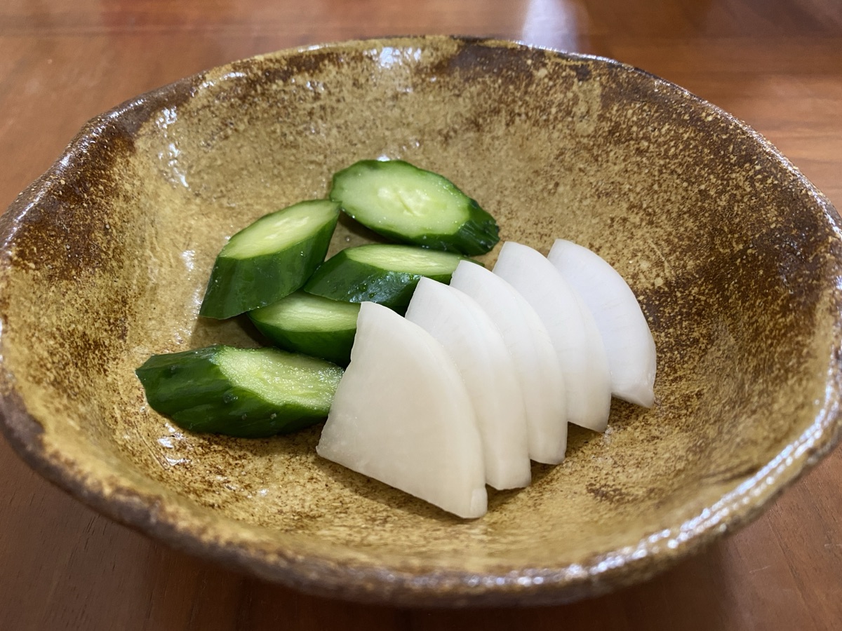 きゅうりや大根などの野菜をまな板の上で本漬けの準備をする様子のイメージ