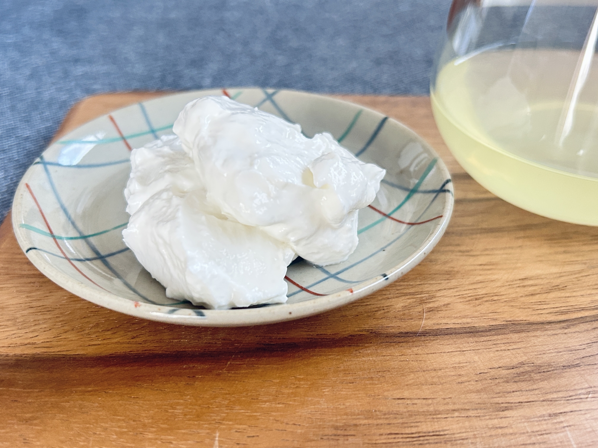 グラスに注がれた透き通ったホエー(乳清)|水切りで出るホエーの活用イメージ