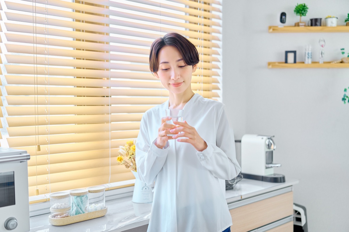 コップの水を飲みながら体調を気遣う女性のイメージ
