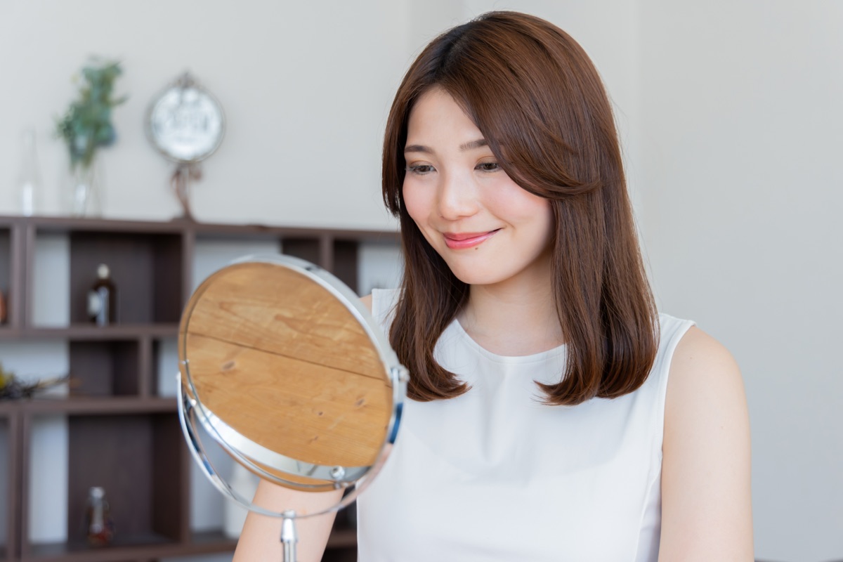自宅でバスローブや大判タオルを準備する女性のイメージ