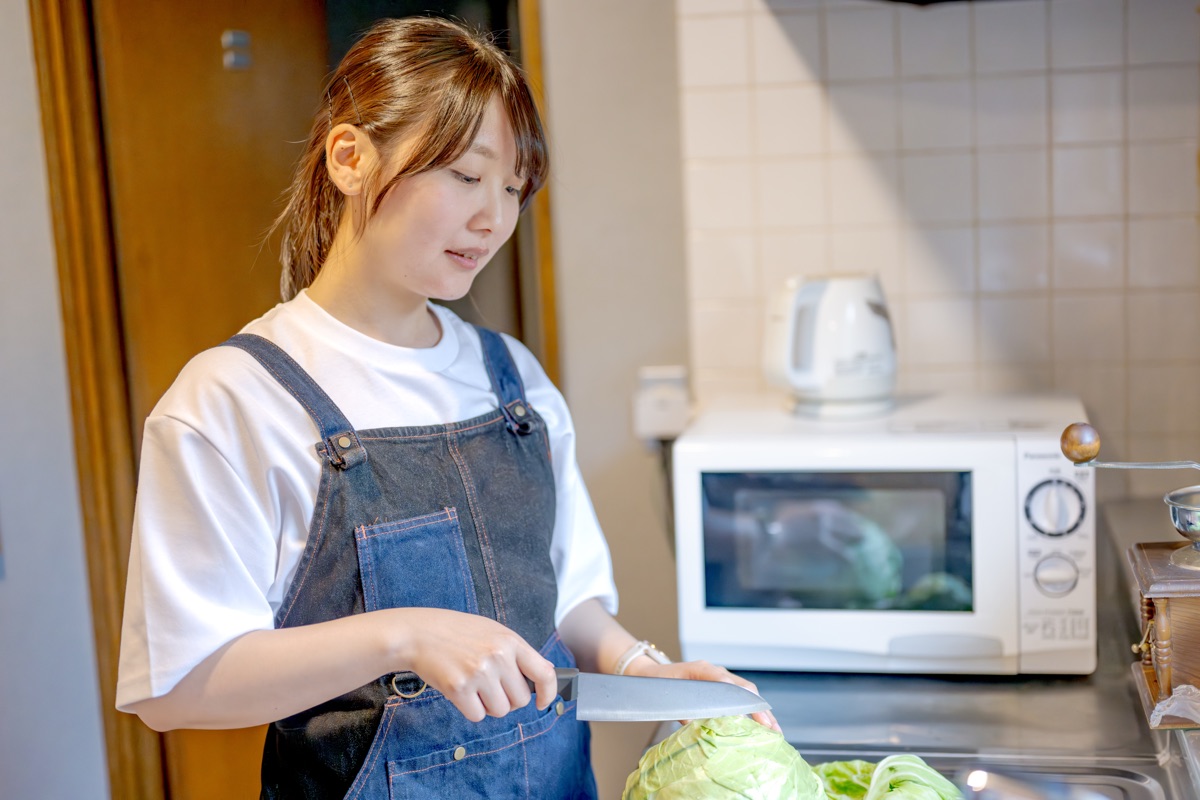 キッチンで日常的に料理をする女性のイメージ