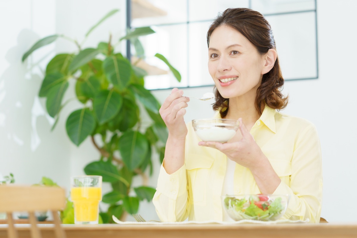 毎朝ヨーグルトを楽しみながら習慣にしている女性のイメージ