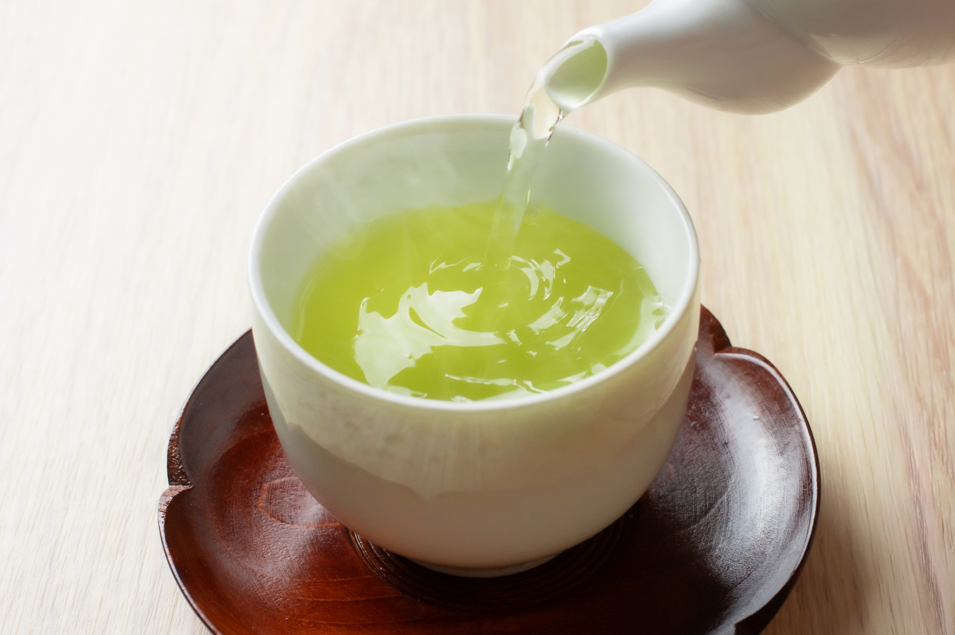 急須から湯呑みに緑茶を注ぐ手元