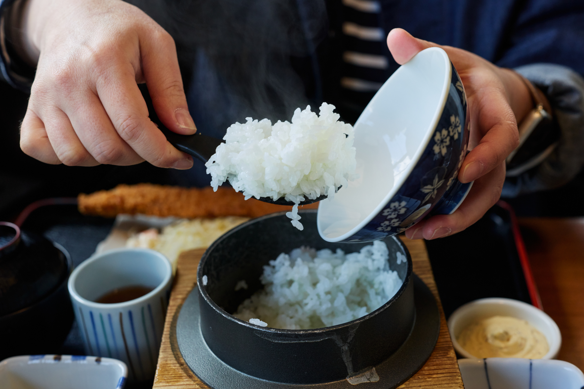 毎日の食卓で箸を持つ手元、日々の食事を表現