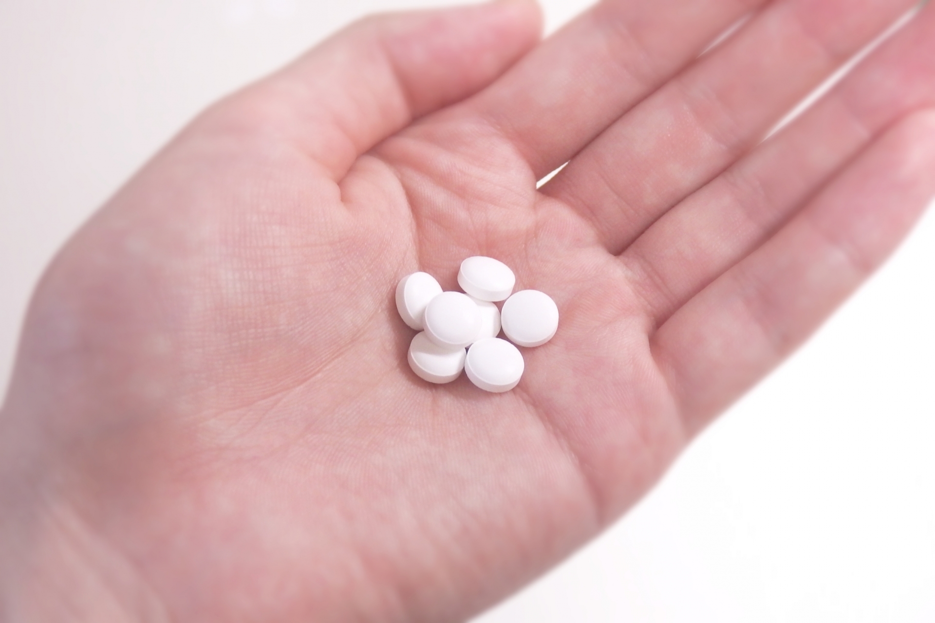 白い錠剤を手のひらに取り出す様子