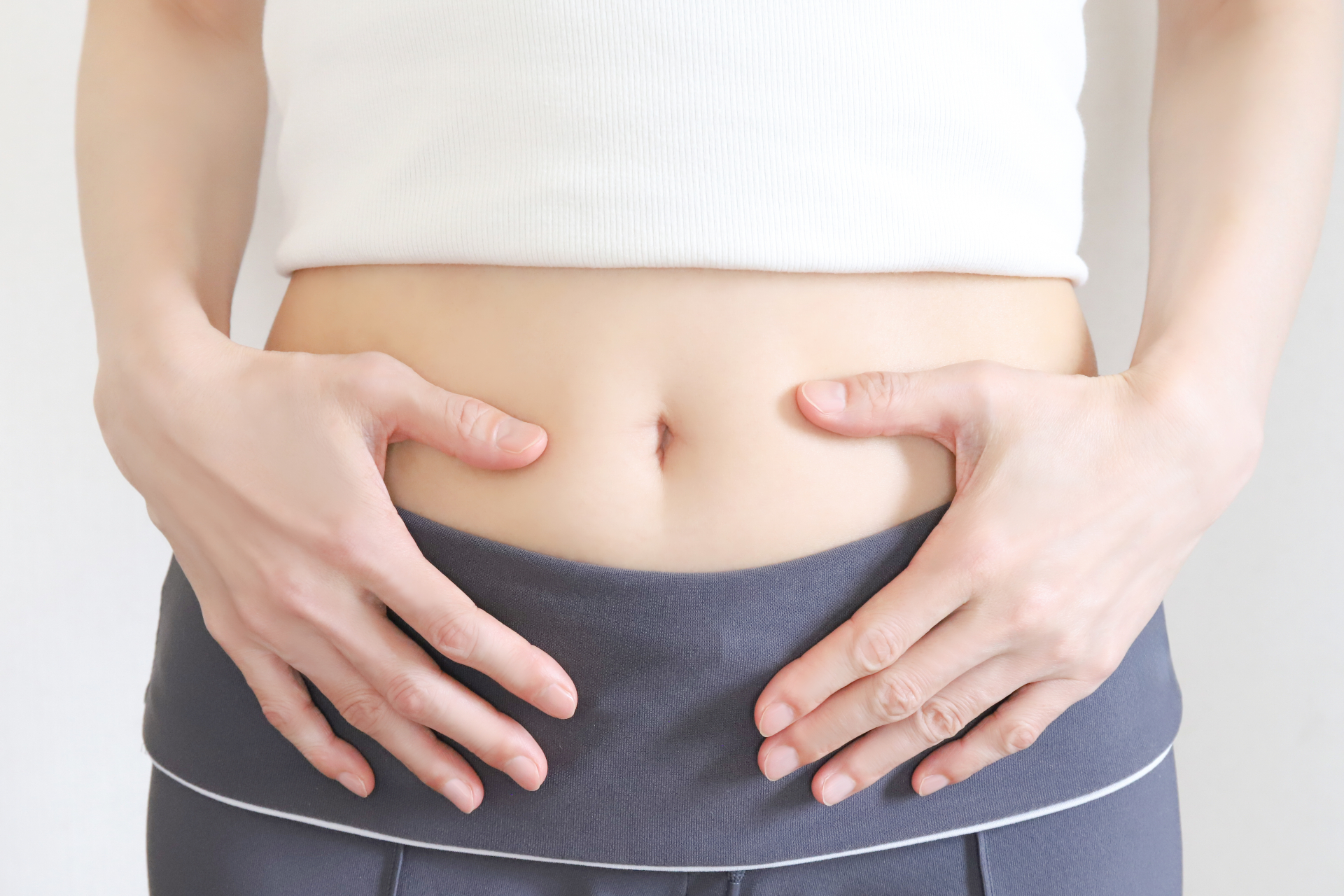 お腹に手を当てる体調を気遣う仕草のカット