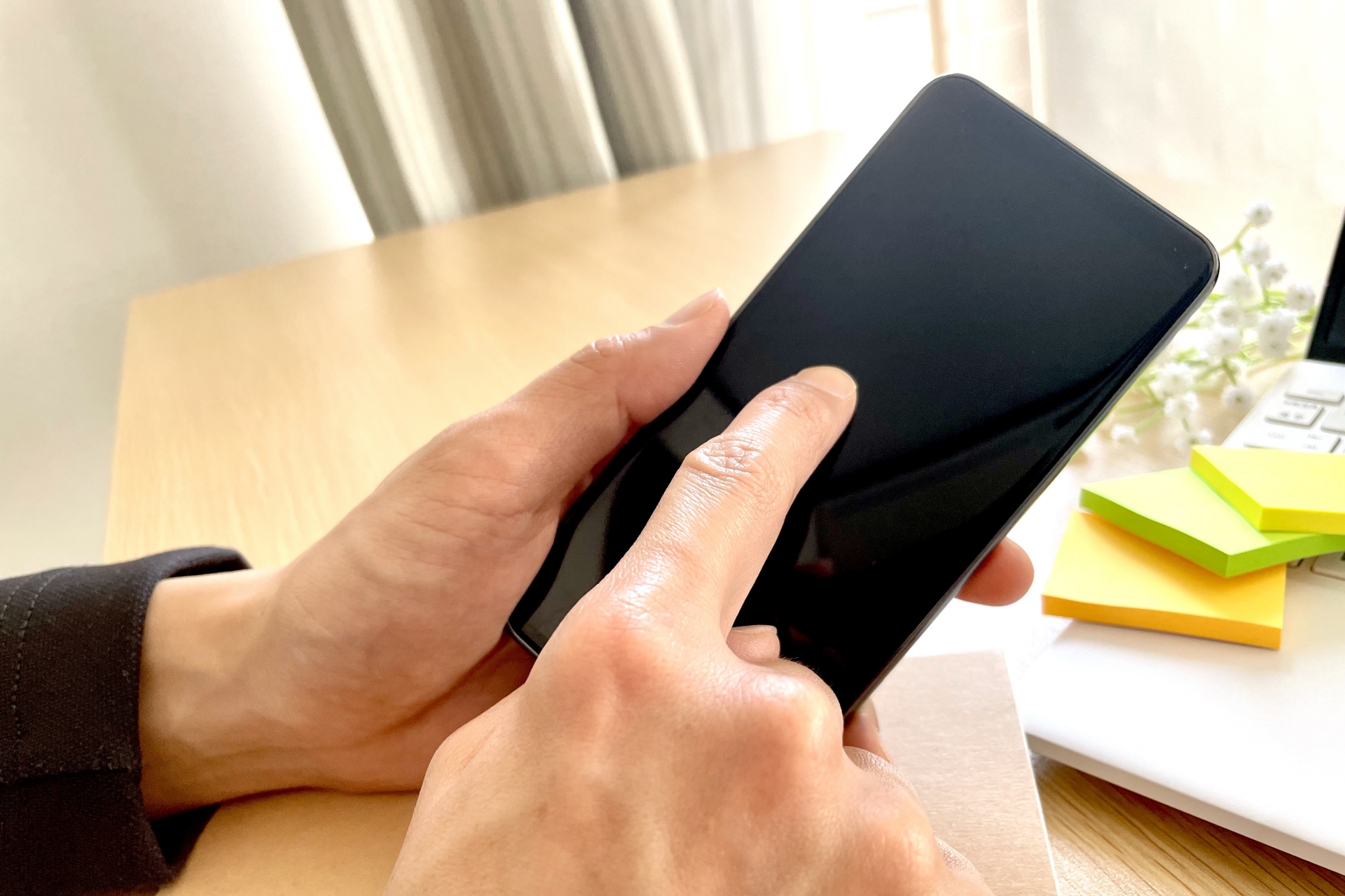 口コミを調べるようにスマートフォンを見る手元