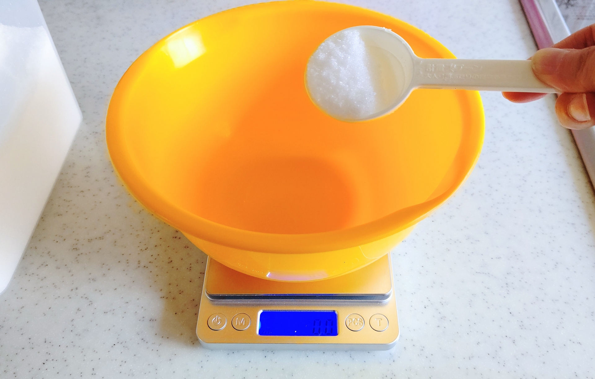 計量スプーンで食材を量る手元、摂取目安を表現